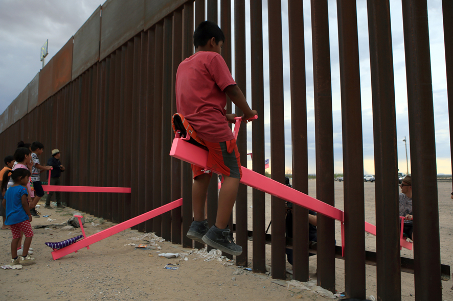 3 LUIS TORRES 28 luglio Ciudad Juarez Messico. Bambini giocano sulle altalene installate dal designer californiano Ronald Rael tra le sbarre del muro che divide US MX